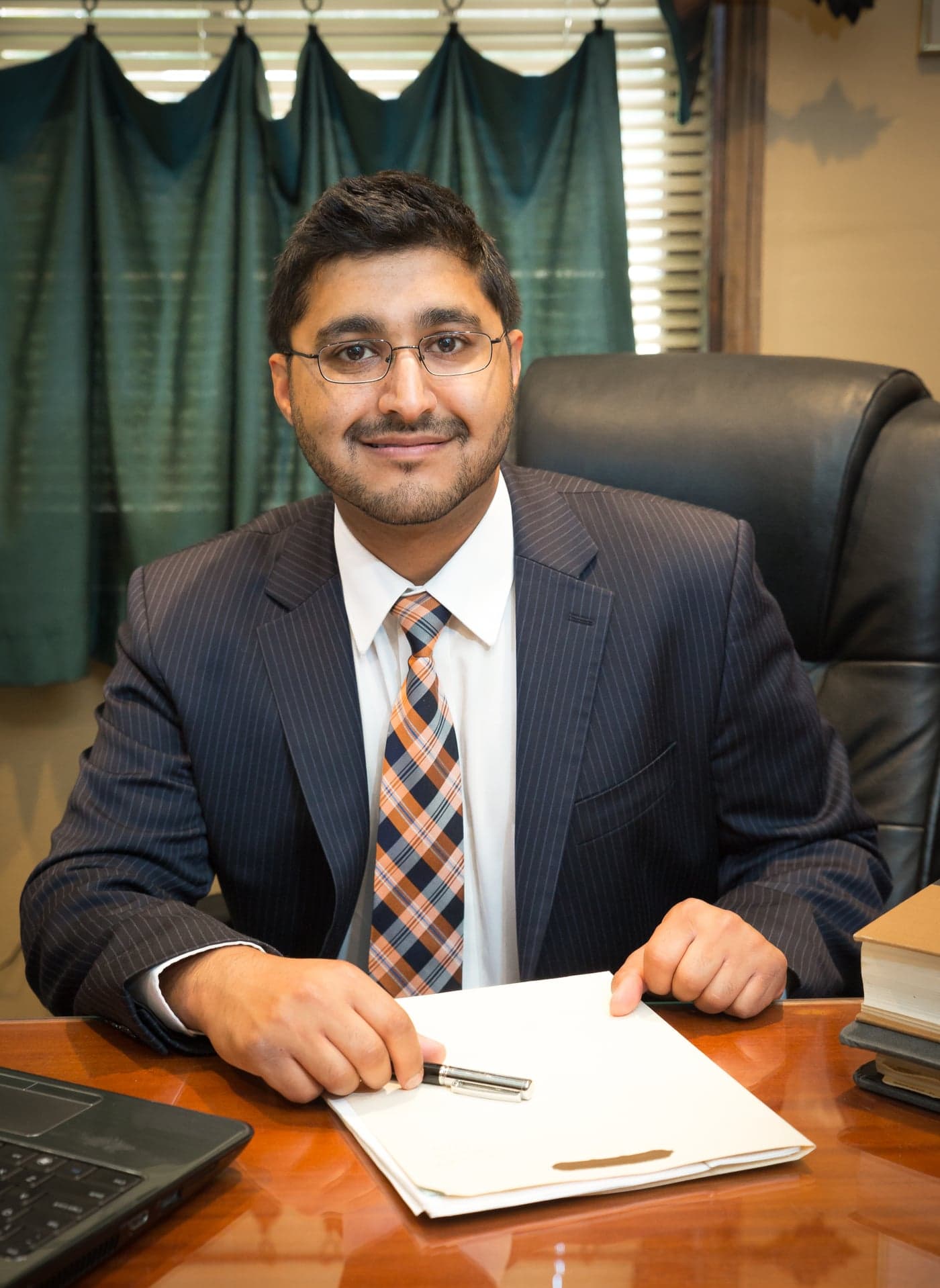 Saif H. Rahman reviewing case documents at his office desk