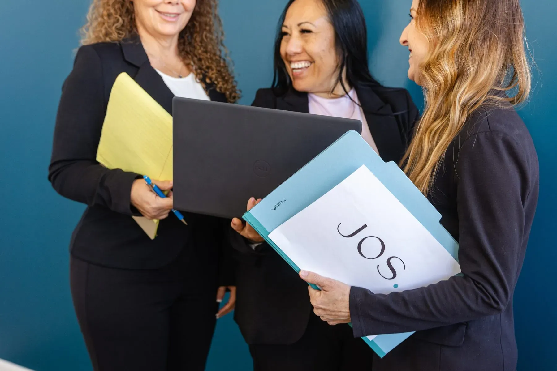 Members of the JOS paralegal team reviewing a case file together over a laptop